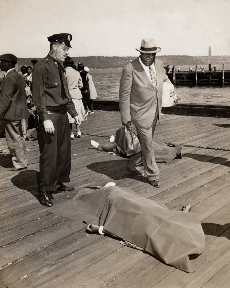 Weegee - Untitled [Police officer and lodge member looking at blanket-covered body of woman trampled to death in excursion-ship stampede, New York], 1941