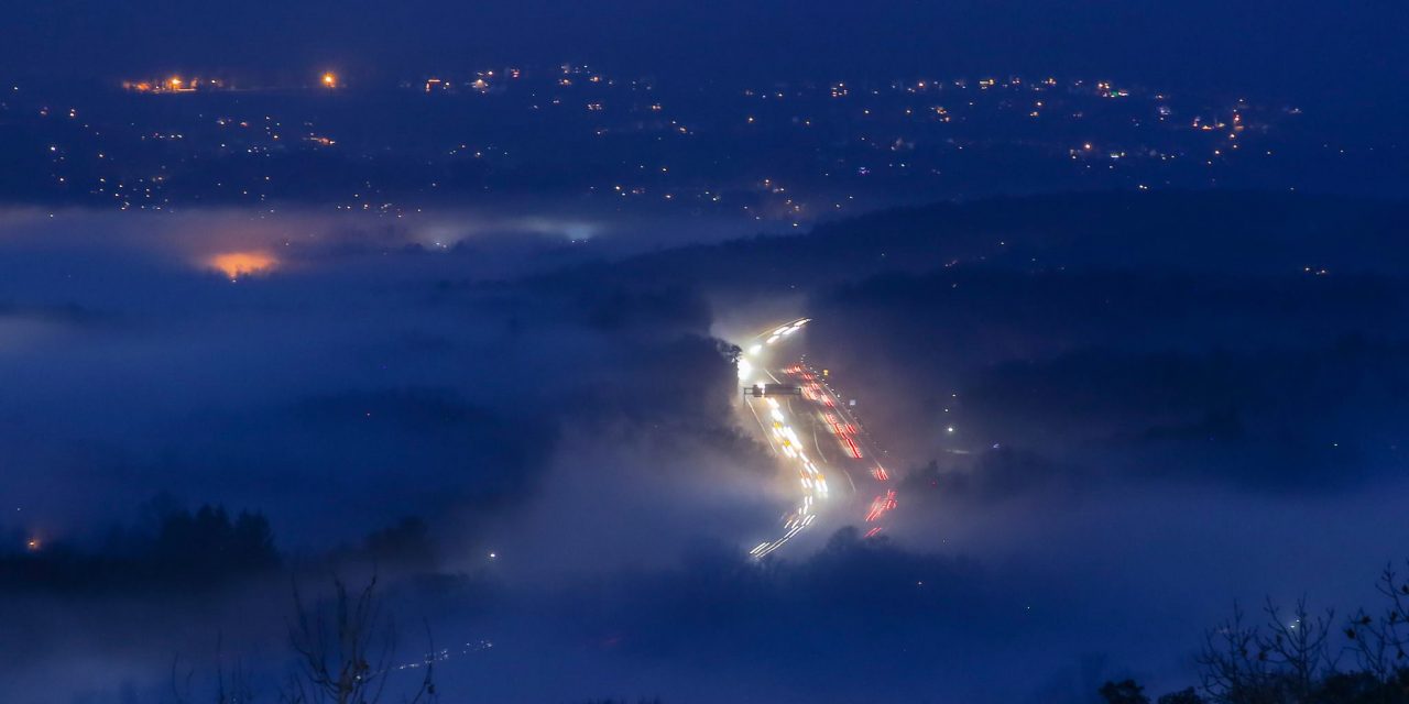 Река автомобильных огней в вечернем тумане